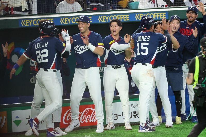 世界棒球經典賽（WBC）C組預賽7日日韓對決，韓國隊1局上半就有攻勢，單局進帳3分，其中李政厚（前左）、瓊斯（Jahmai Jones）（前右背對者）靠著隊友安打推進，雙雙回到本壘得分。圖/中央社