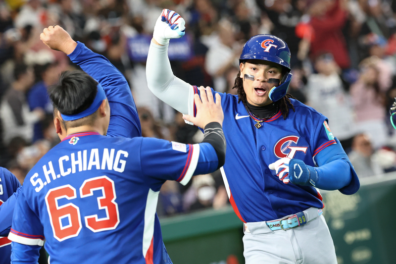 世界棒球經典賽（WBC）8日在東京巨蛋上演台韓大戰，2局中華隊張育成（右）擊出陽春砲後，振臂高呼與隊友擊掌互賀。圖/中央社