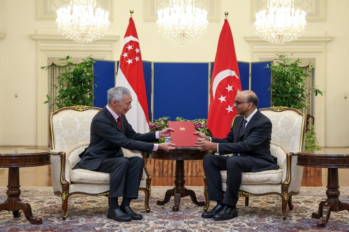 新加坡第三任總理李顯龍（左）周一親自向總統尚達曼（右）遞交辭呈。圖/取自李顯龍《臉書》