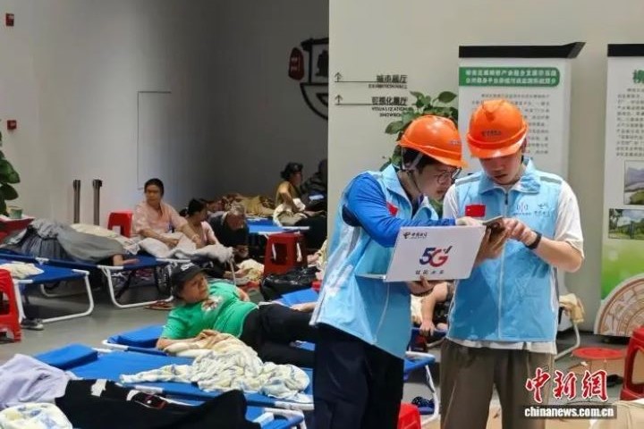 工作人員在臨時安置點保障受災民眾通信。圖/取自中新網