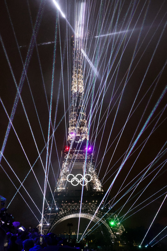 高掛奧運五環的著名地標艾菲爾鐵塔也成典禮中一大亮點，黑夜中無數光線自鐵塔迸射而出，令花都巴黎越夜越美麗。圖/中央社