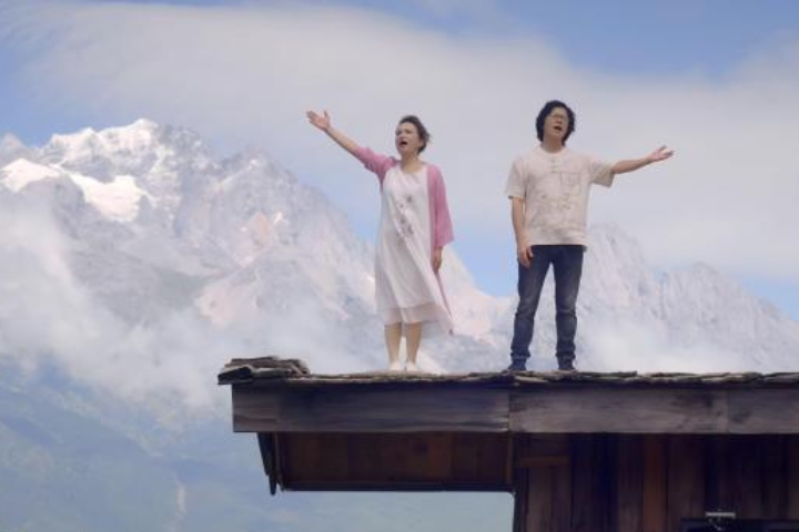 兩岸夫妻音樂人游純瑜(左)與謝學飛(右)在民歌大觀獻唱原創歌曲《兩岸一家親》。圖/翻攝自中新社視頻