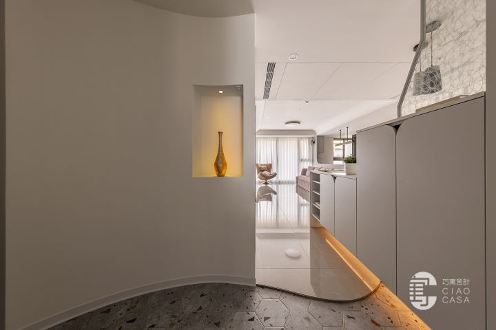 以曲面量體柔化斜切格局,巧寓舍計鋪陳藝術端景與六角磚地坪,串起流動迎賓序列。圖/歐德集團提供