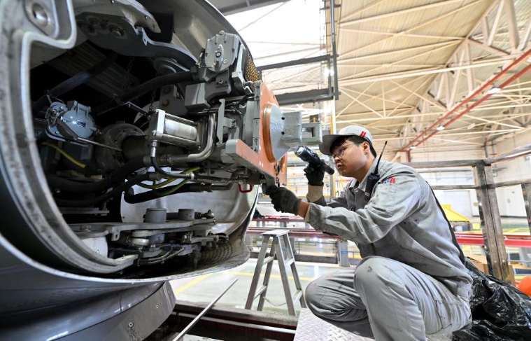 機械師對列車的車頭進行檢查維護。圖/新華社