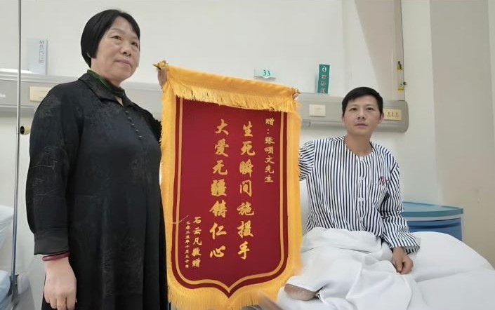 獲救的石姓男子特別製作錦旗向張頌文表達感謝，錦旗上寫著「生死瞬間施援手，大愛無疆鑄仁心」。圖/取自影片