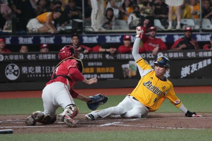 台灣大賽由味全龍隊與中信兄弟隊爭冠，21日關鍵第4戰6局下半，兄弟王威晨（右）從二壘一路奔回本壘，經重播輔助判決確認成功得分，助隊追平比數。圖/中央社