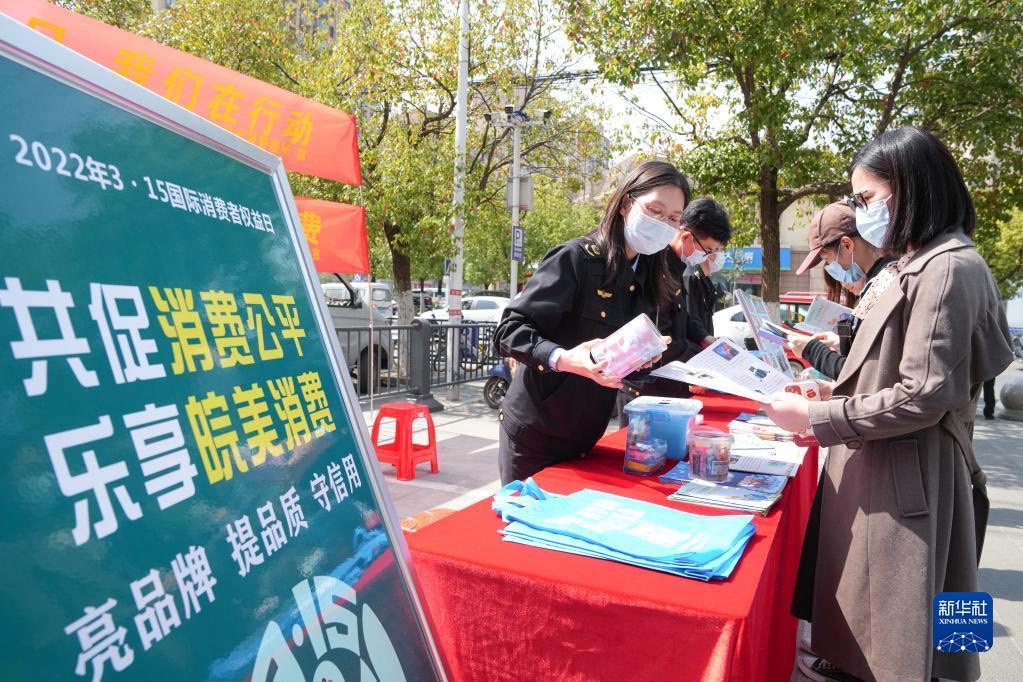 3月11日，在合肥市一家超市門前，市場監管所工作人員接受消費者咨詢。圖/取自新華社