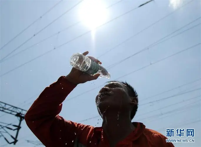 一名工人在酷熱太陽底下澆水降溫。圖／新華社