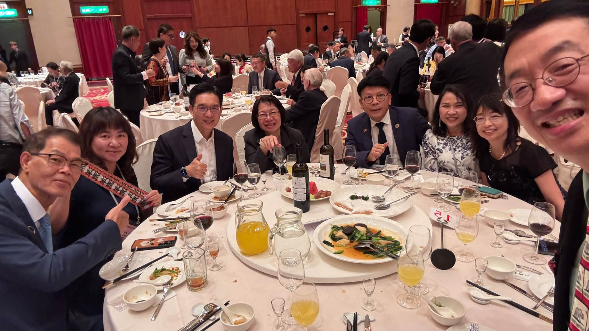 一年一度的僑務委員會議與晚宴上,有與會人員手持「洋流」飄帶。圖/取自吳怡明臉書