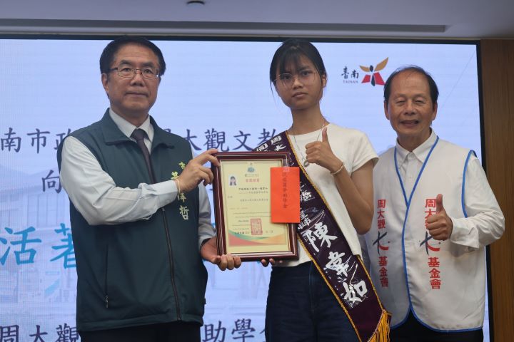 台南市長黃偉（左）哲頒獎給罕癌綠能工程師陳韋如（中）生命鬥士獎。圖/周大觀文教基金會提供
