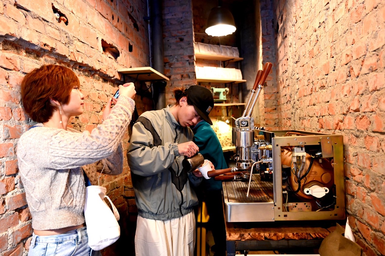 四川成都，顧客在「縫紉機」迷你咖啡小店內拍攝咖啡製作過程。圖／  中新社