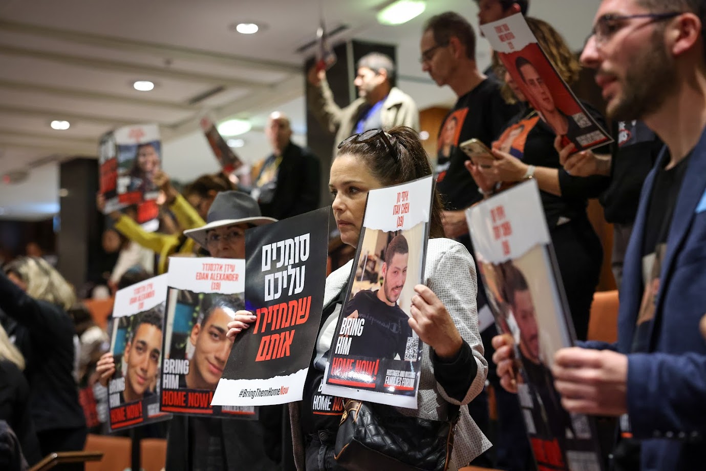 以色列國會全體會議，旁聽席上有人質家屬舉著標語抗議。圖/取自The Knesset @KnessetENG