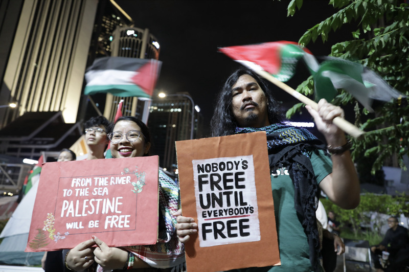 馬來西亞民眾跨年夜舉標語牌聲援巴勒斯坦人，抗議以色列圍困加薩。圖/取自中央社