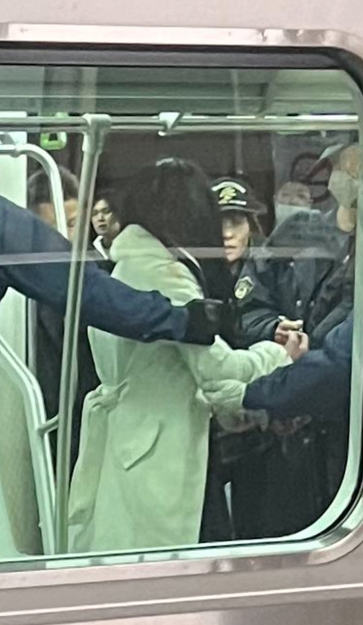 身穿淺色大衣的女子遭到警方上銬帶走。圖/取自Kyotonese.eth《推特》