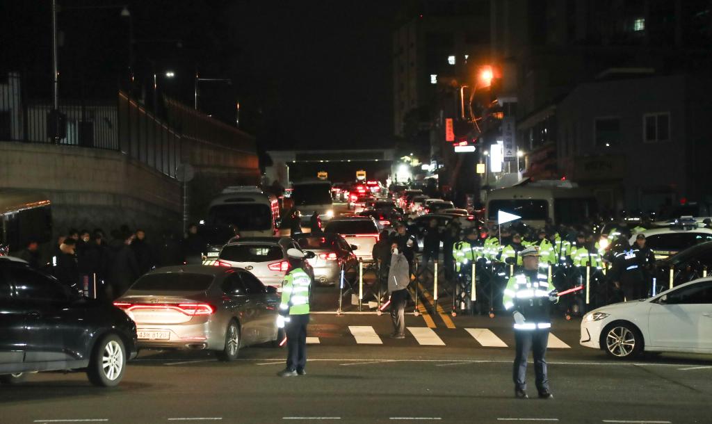 韓國總統尹錫悅突襲宣布緊急戒嚴引發風波，民眾4日傍晚聚集在國會大樓前，要求尹錫悅下台、當局立即調查內亂行為。圖為12月4日凌晨，警察在韓國首爾的總統府外戒備。圖/取自新華社