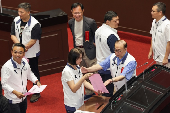 立法院會25日舉行司法院大法官人事同意權案投票表決，國民黨立委在開完黨團大會後率先進議場投票，在投進票匭前技術性亮票。圖／中央社