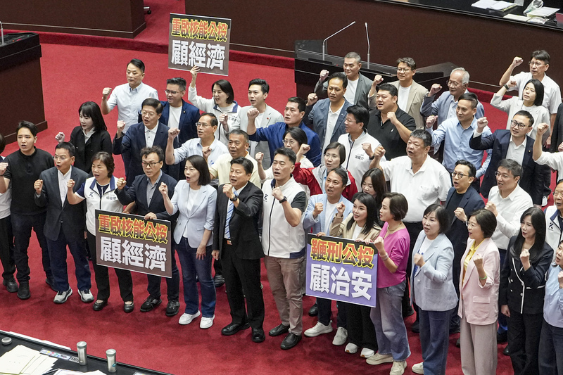 立法院會14日處理藍白兩黨團提出的公投提案，國民黨立委齊聚議場，高舉「重啟核能公投、顧經濟」及「鞭刑公投、顧治安」手板，高呼口號表達支持立場。圖/中央社