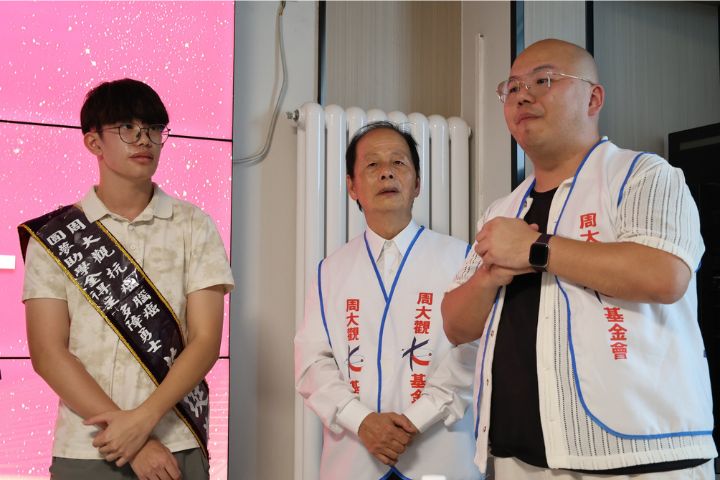 台灣周大觀基金會創辦人周進華（中）頒發抗癌圓夢助學金腦癌多障勇士莊珽翔（右）。圖/台灣周大觀文教基金會提供