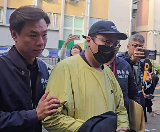 圖為去年11月5日,在美方制裁柬埔寨太子集團犯罪組織後,檢調發動偵蒐行動,調查局幹員移送第二波在台重要幹部王昱棠(黃衣)至台北地檢署複訊。圖/中央社