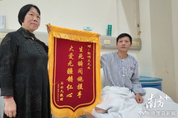 11月11日，石先生在住院病房展示準備好的錦旗，上面寫著「生死瞬間施援手 大愛無疆鑄仁心」。圖/取自《南方日報》