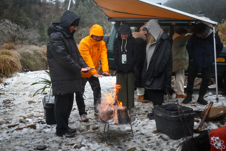 寒流來襲，山區賞雪民眾圍營火取暖。圖/取自中央社