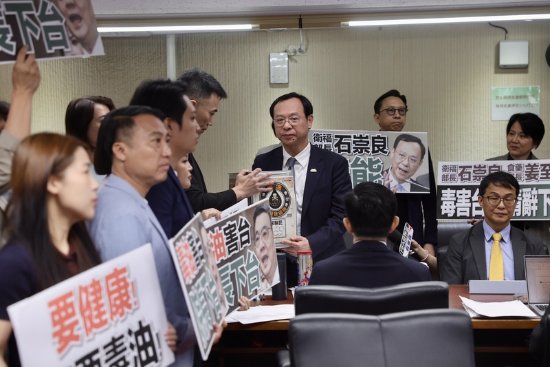 中聯油品致癌物苯駢芘超標案滾雪球，立法院社福及衛環委員會8日邀衛福部長石崇良等專題報告「食安問題爆不停，如何構建使國人安心生活、就學與食品廠安全管理精進作為」並備質詢，在野黨立委群起要求官員下台負責，並將象徵毒油的沙拉油桶交給衛福部長石崇良（中右）。圖/中央社