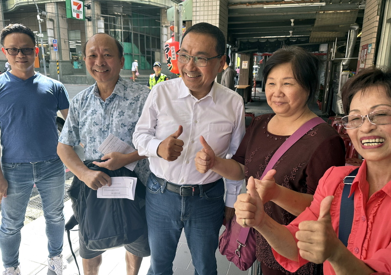 國民黨主席選舉18日登場，新北市長侯友宜（前中）近中午時，前往國民黨新北市黨部樓下的板橋區黨部投票，並與在場投票的黨員問好、合影。圖/中央社