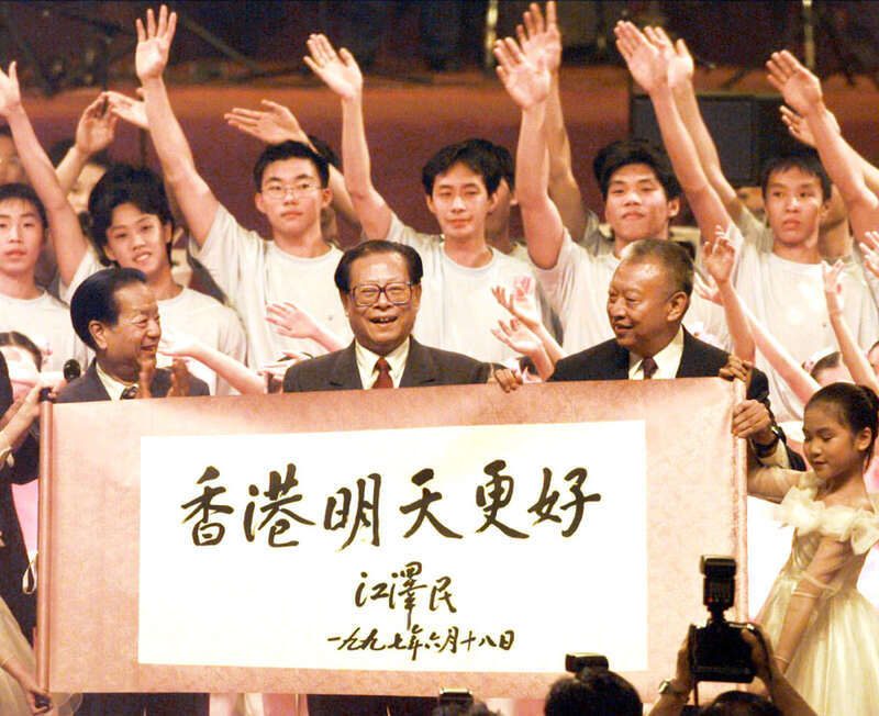 1997年香港回歸，中共總書記江澤民（中）在國務院主管港澳副總理錢其琛（ 左）陪同下親赴香港與會，其右為第一任香港特首董建華。圖／取自央視