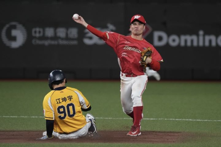   台灣大賽關鍵第4戰21日繼續在台北大巨蛋舉行，味全龍與中信兄弟隊比分緊咬，9局下，龍隊二壘手李凱威（右）完成雙殺守備，比賽宣告進入延長賽。圖/中央社