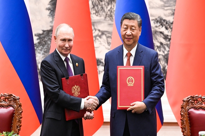 普丁（左）與習近平（右）簽署《中華人民共和國和俄羅斯聯邦在兩國建交75周年之際關於深化新時代全面戰略協作伙伴關系的聯合聲明》。圖/取自新華社