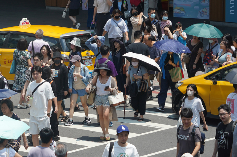 北市近日飆高溫，台北中山商圈中午逛街民紛紛撐傘擋豔陽。圖/中央社