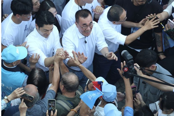 國民黨新北市長參選人李四川（中白衣）造勢大會4日在板橋第一運動場舉行，台北市長蔣萬安（左2白衣）、新北市長侯友宜（右2白衣）一同進場，與群眾握手互動。圖/中央社