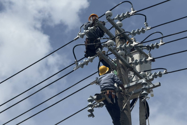圖為颱風丹娜絲造成嘉義縣大停電，台電人員13日頂著烈日，在沿海地區全力搶修電桿。圖/中央社