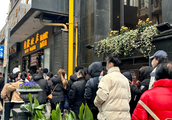 上海黃河路上的國際飯店西餅屋門口，顧客大排長龍。圖/取自北京《經濟日報》