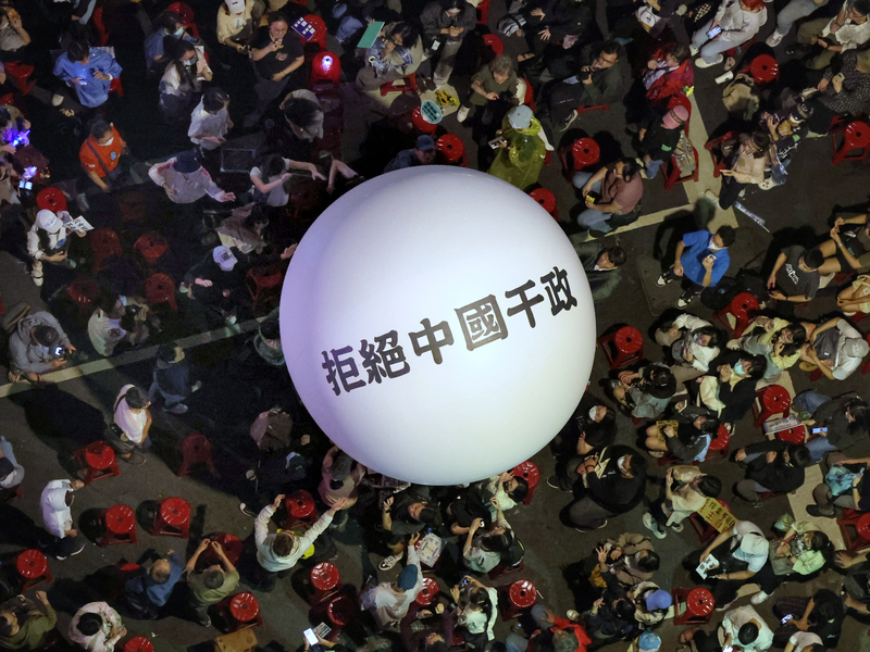 民眾28日到立院外抗議國會改革五法，抗議群眾舉著「拒絕中國干政」的白色大球。圖/中央社