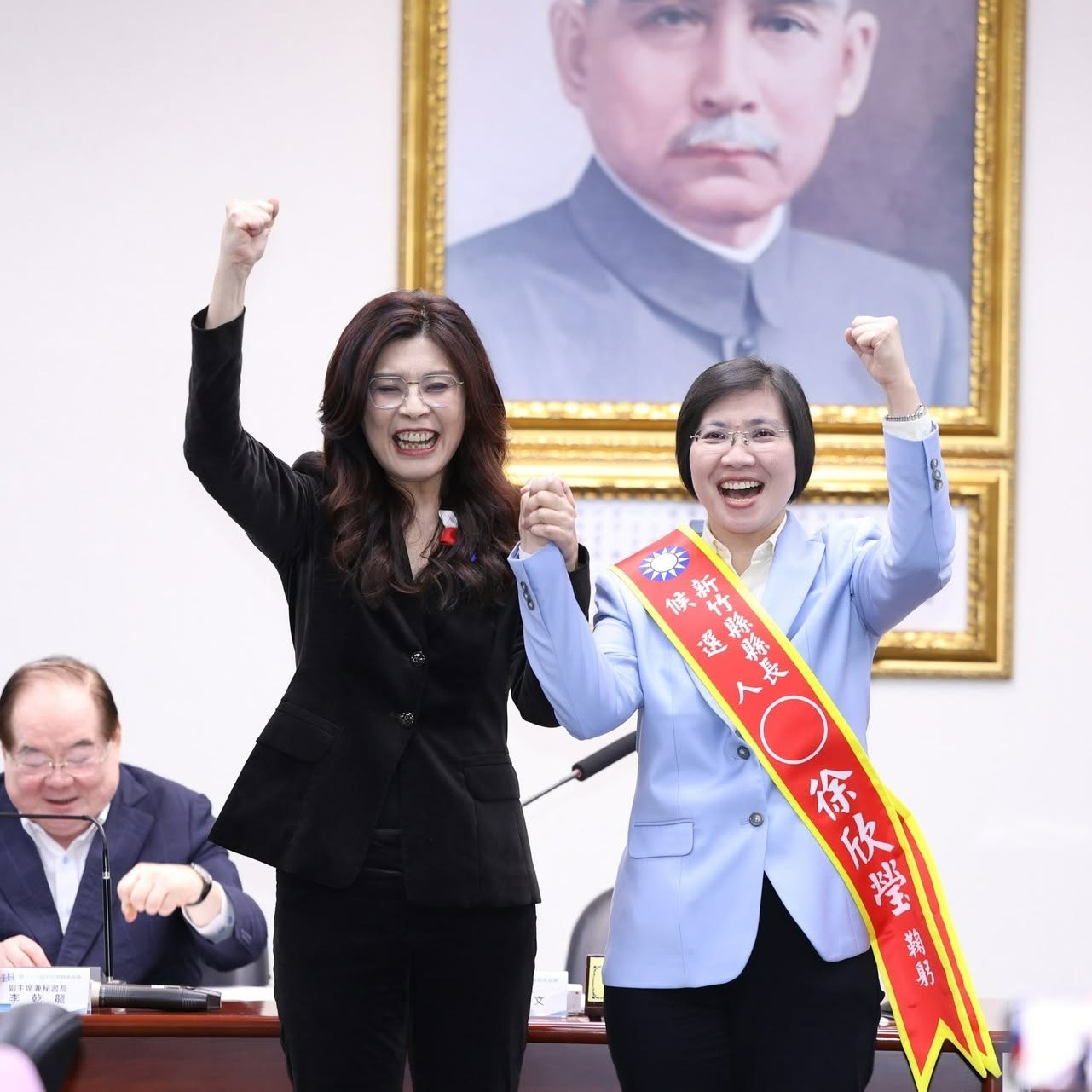 新竹縣初選徐欣勞獲勝後，國民黨主席鄭麗文在中常會為徐欣瑩右（右）披戰袍。圖／取自徐欣瑩臉書