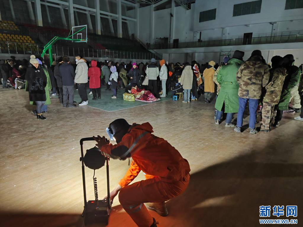 新疆阿克蘇地區烏什縣地震後，部分區域發生停電，電力公司人員在臨時收容所架設照明設備。圖／取自新華社