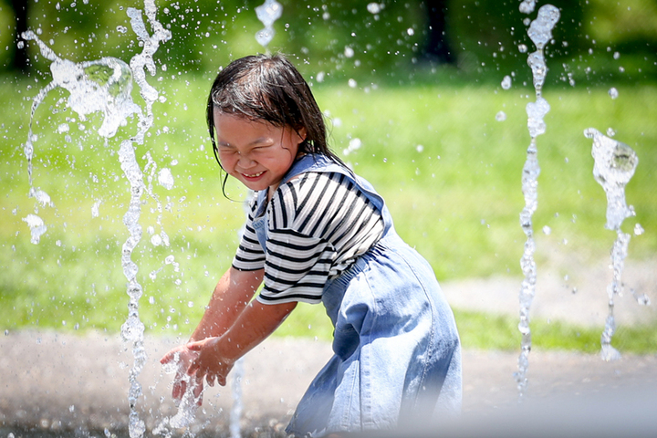 清涼一下，孩童在酷熱的太陽下玩水。圖/取自中央社