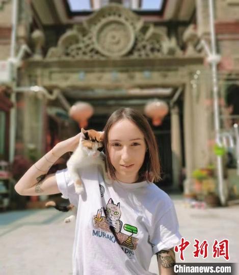 法國女孩樂蓋曦與她在上海領養的貓。圖/取自中新網