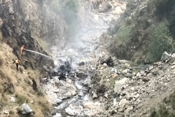 救援人員向墜谷燃燒的汽車噴水滅火。圖/取自DW News官方《YouTube》頻道