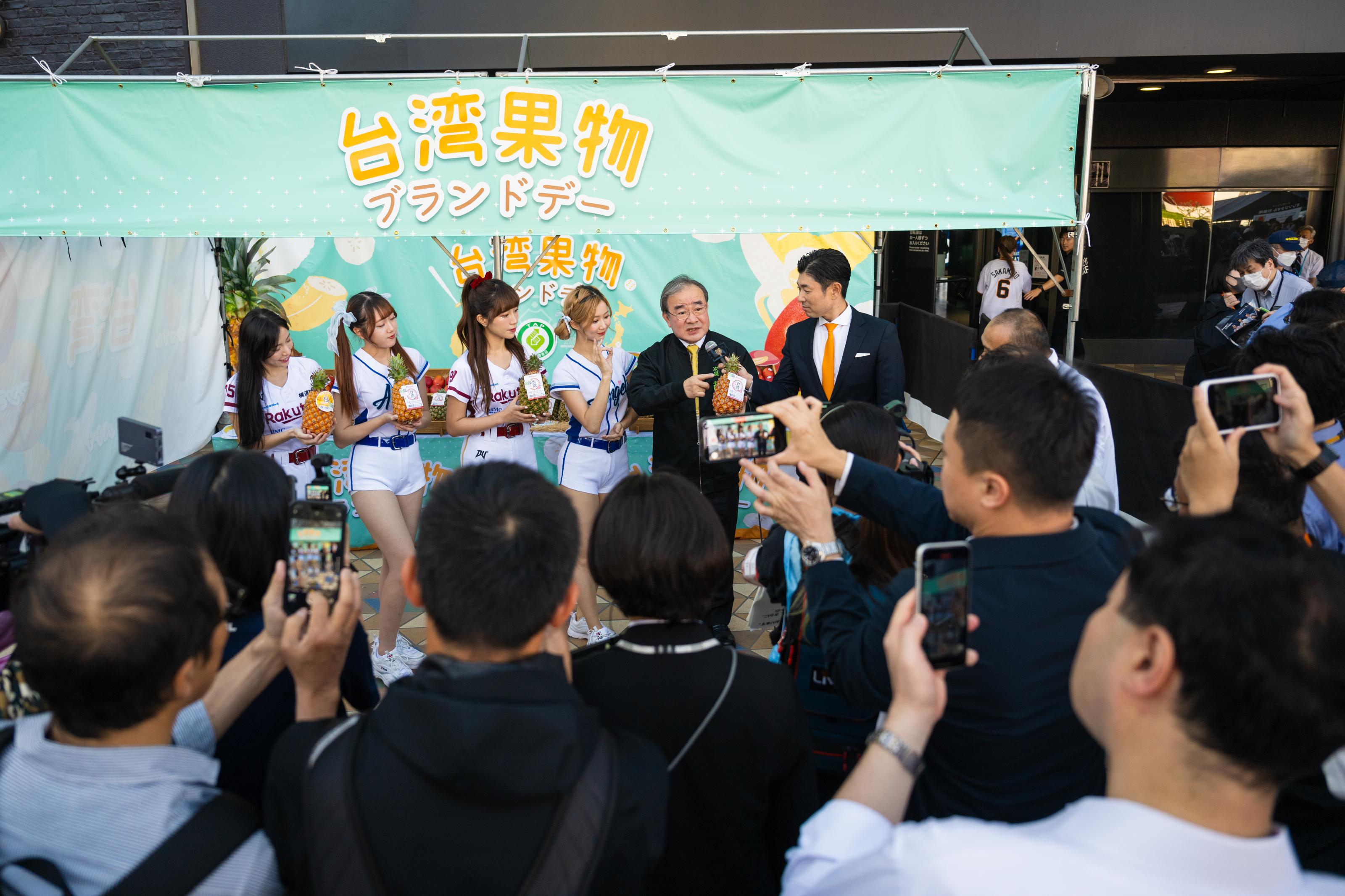胡忠一（右2）於東京巨蛋前廣場設置攤位介紹台灣水果，吸引日本民眾圍觀。圖/農業部網站
