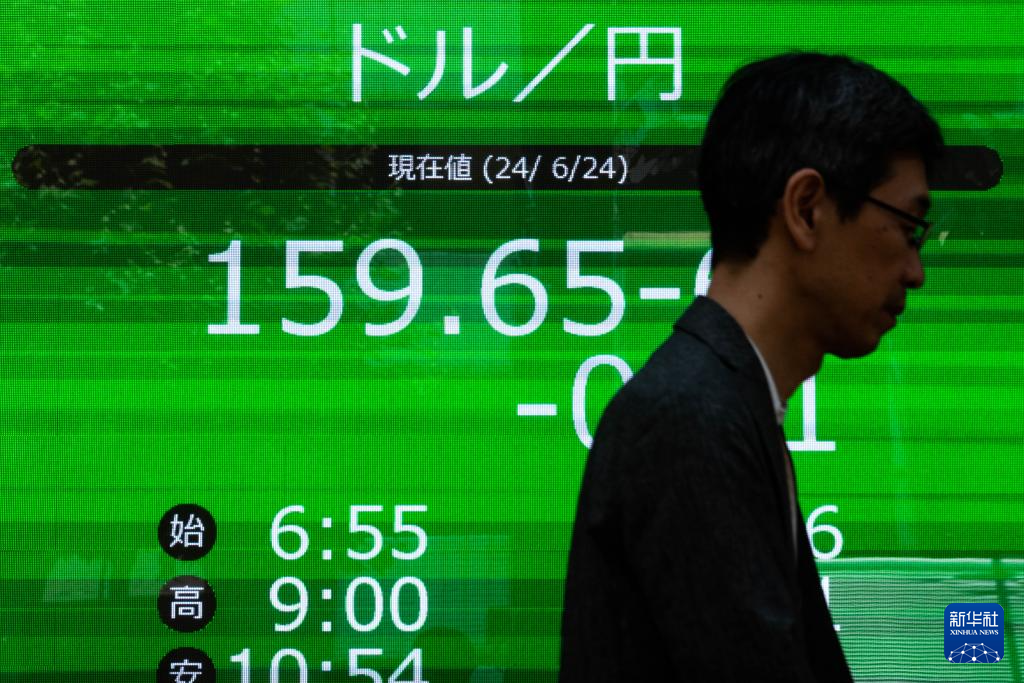 6月24日，行人走過日本東京一處顯示實時匯率的電子屏幕。圖/取自新華社