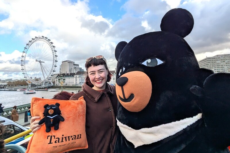 英國插畫家漢娜（左）為台灣設計的觀光巴士全車身廣告12月在倫敦上路，她10日與觀光署吉祥物「喔熊」一同乘車體驗。圖/中央社