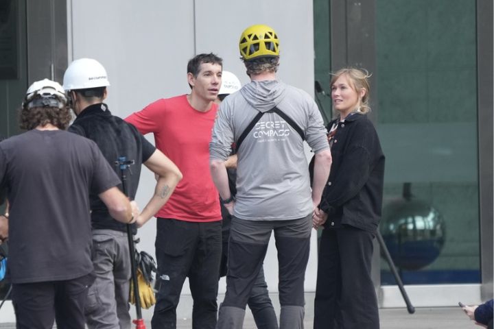 霍諾德(Alex Honnold)(左3)25日將徒手攀登台北101大樓,出發前與妻子桑妮(Sanni McCandless)(右)在廣場外場勘,跟技術人員交換意見。圖/中央社