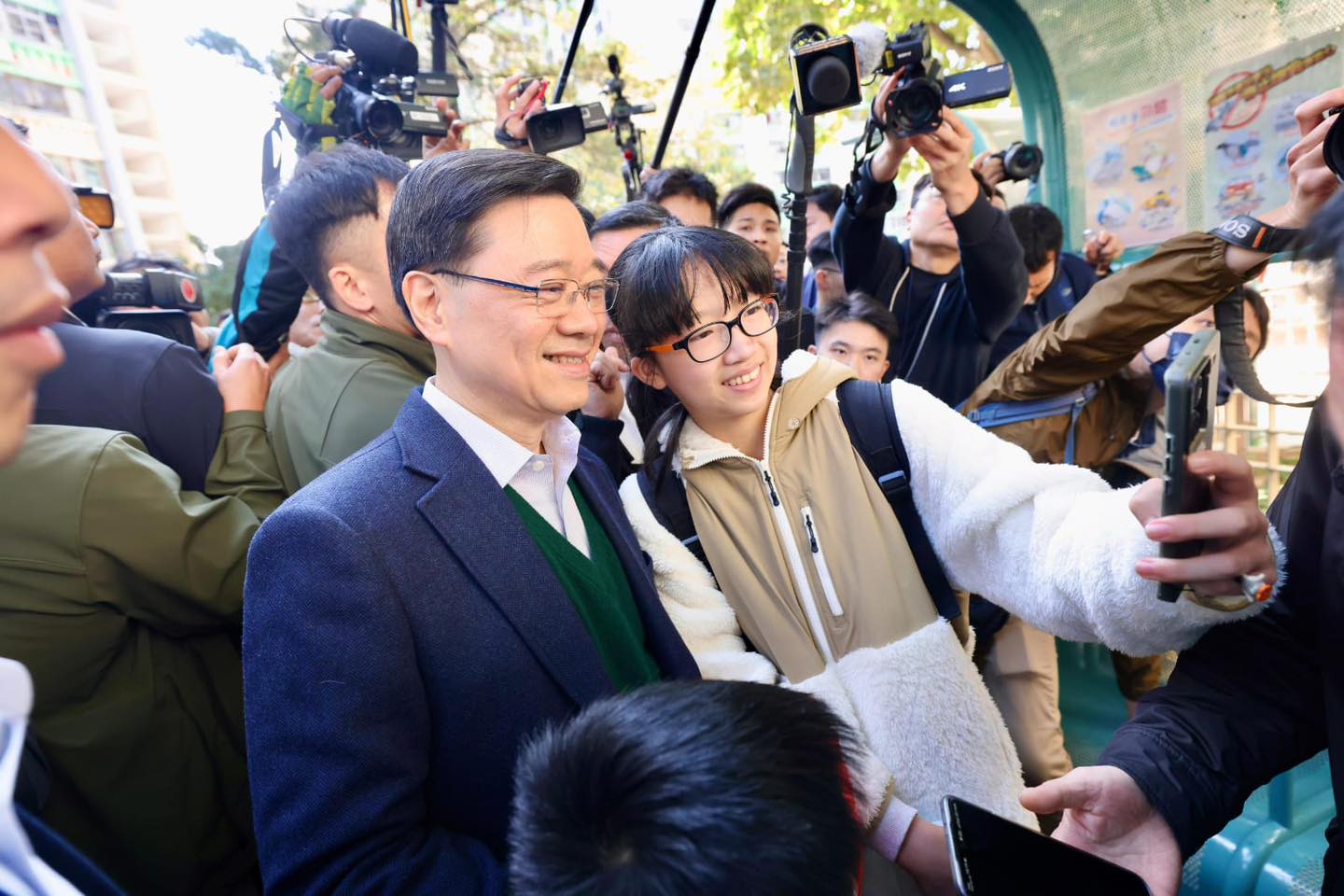 針對長和實業擬出售包括巴拿馬運河兩端港口業務，中共國務院港澳辦及中聯辦表關切後，香港特首李家超（左）18日發表3點看法。圖為李家超與學生合影。圖／取自李家超臉書