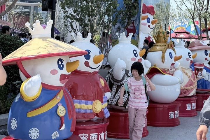 蜜雪冰城總部旗艦店外,小朋友急著和充滿童趣公仔拍照留念。圖/記者陳素貞攝