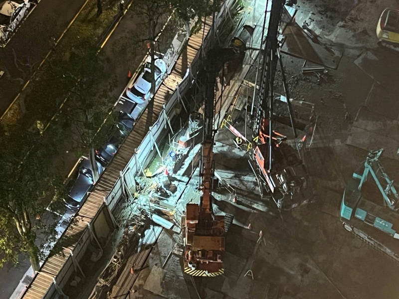 台北市松山區慶城街1處新建工地晚間9時發生地層下陷，導致緊鄰工地圍籬的4輛汽車傾斜，警消獲報已封鎖現場。圖/中央社