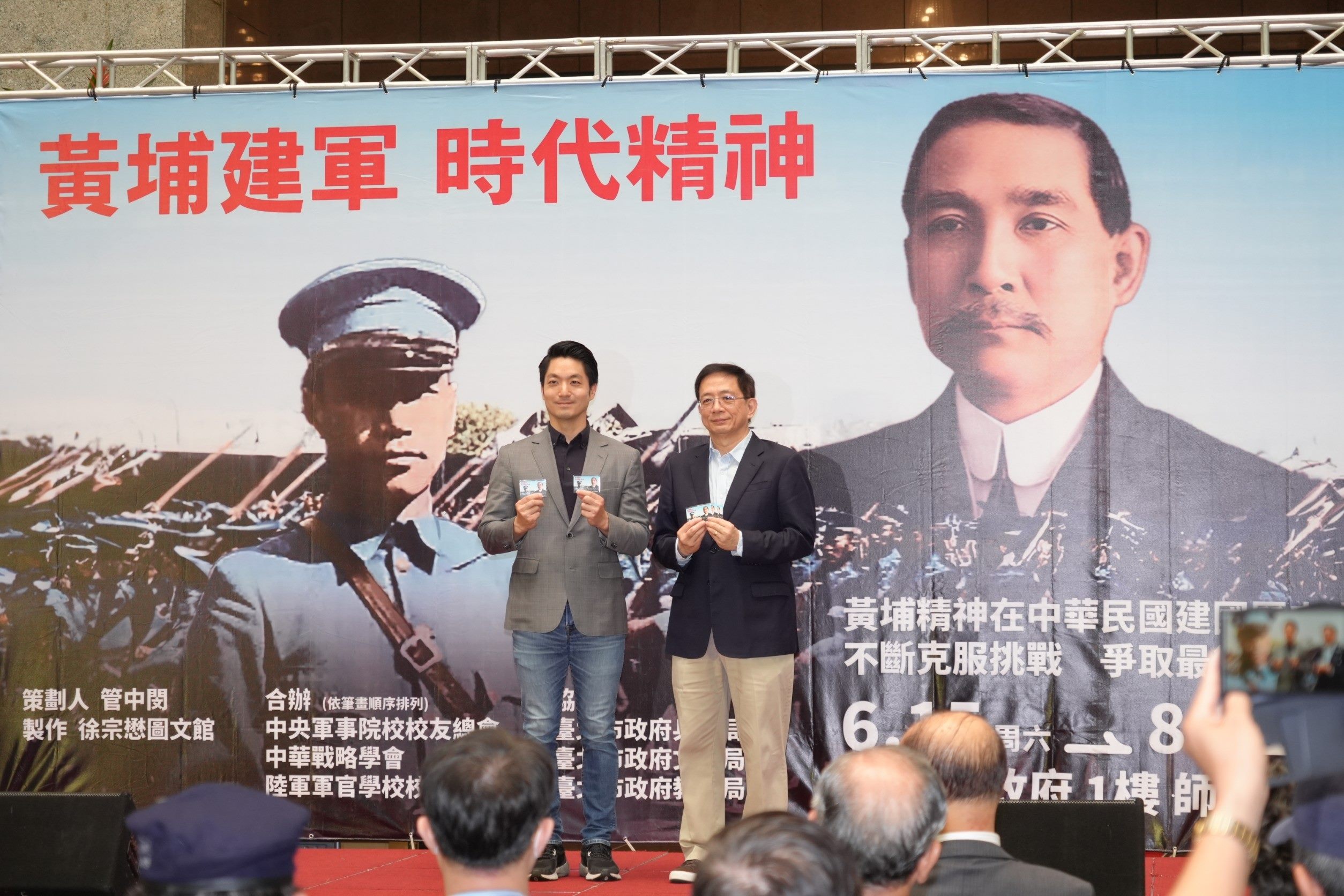 台北市長蔣萬安（左）與「黃埔建軍的時代精神」特展策畫人管中閔一起展示黃埔百年紀念悠遊卡。圖/北市府提供