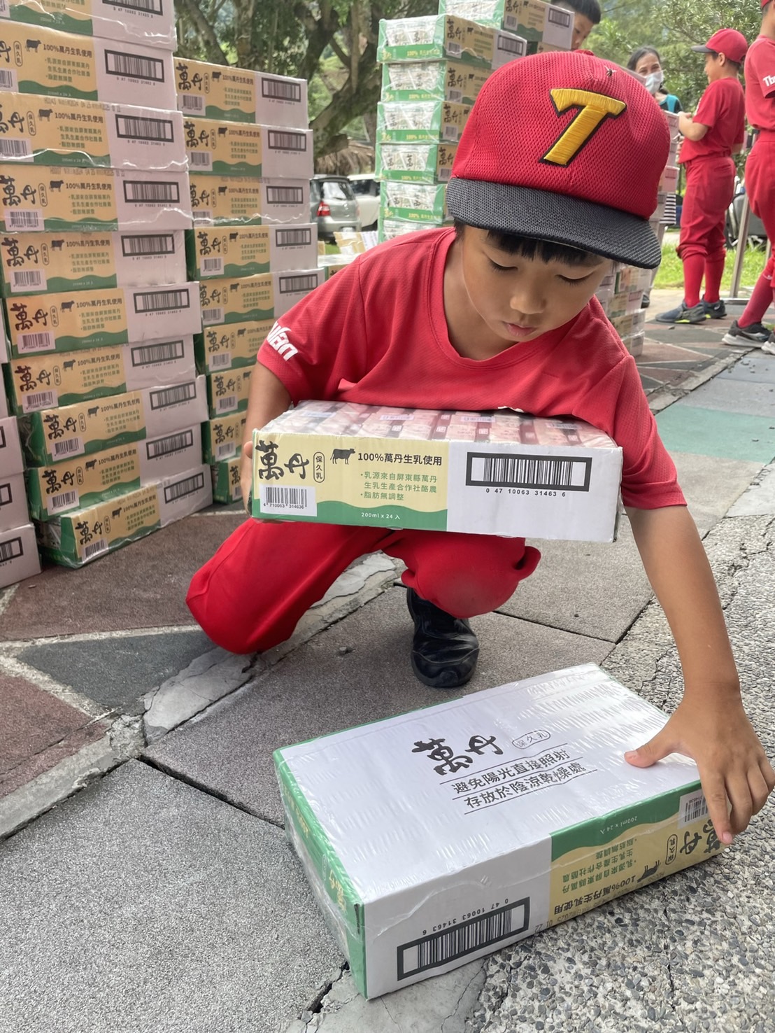 德芙蘭國小球員協助搬運牛奶。圖/頂新和德文教基金會提供