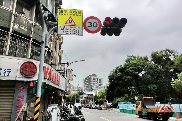 新北市三峽區日前發生重大車禍，在北大國小前路段現已更新通學區標誌，且為進一步提高駕駛人警覺性，目前三峽警分局於上下學時段都會派員協助疏導與管制交通。圖/中央社